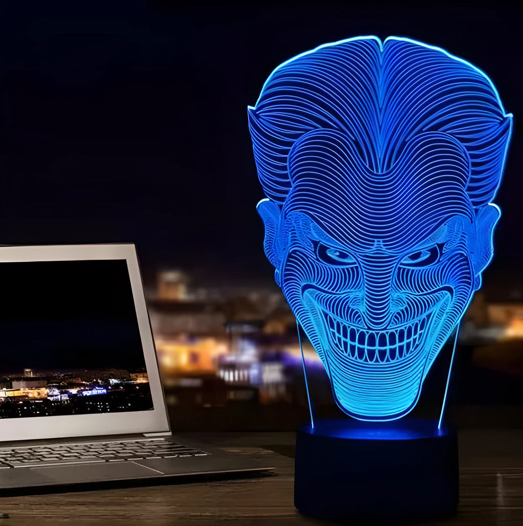 A 3D acrylic LED lamp with a square base, displaying one of its seven colour options on a desk.