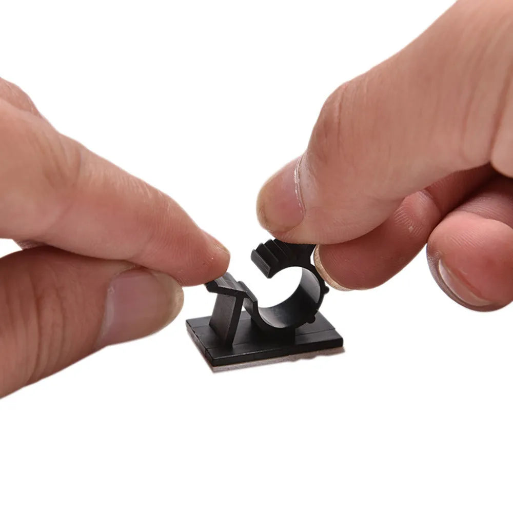 Ten black nylon adhesive cable clamps for wire management, showing two-stage lock design.