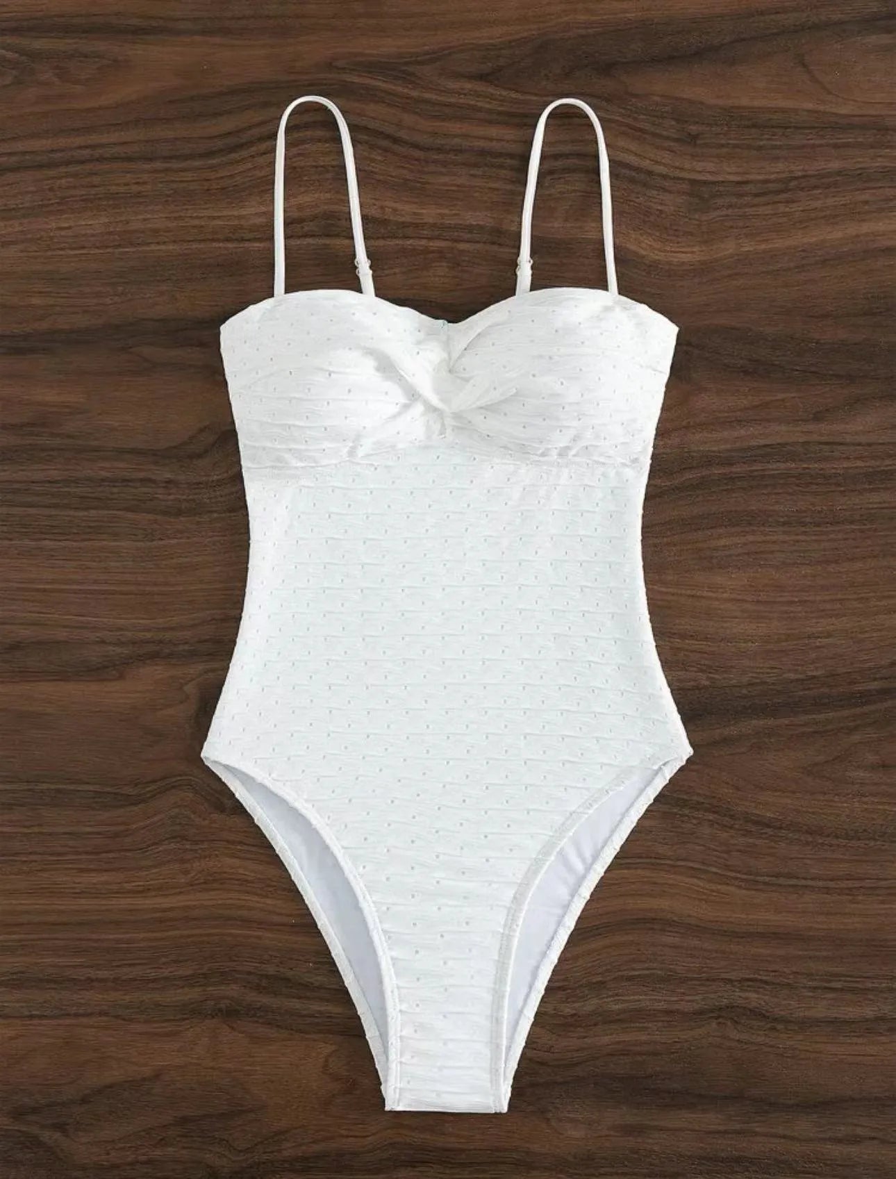 White one-piece swimsuit for women on a hanger, showing briefs style and sling detail.