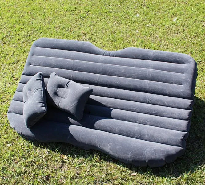 Inflatable car bed with flocked surface and two pillows, shown inside a five-seater vehicle.