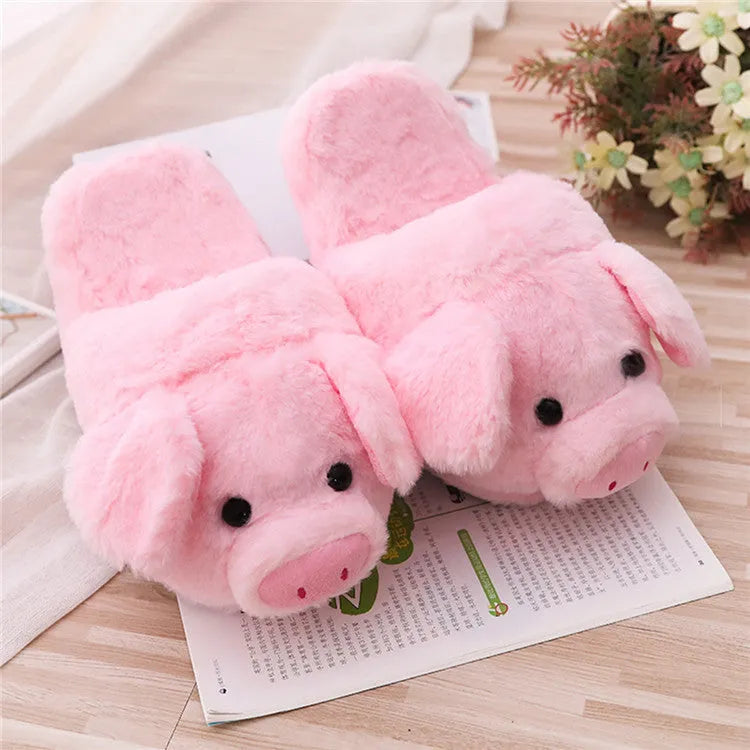 Pink pig-shaped plush floor slippers on a plain background.