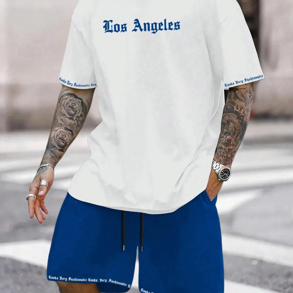 Man wearing a blue printed sports-style short-sleeve top and matching shorts set.
