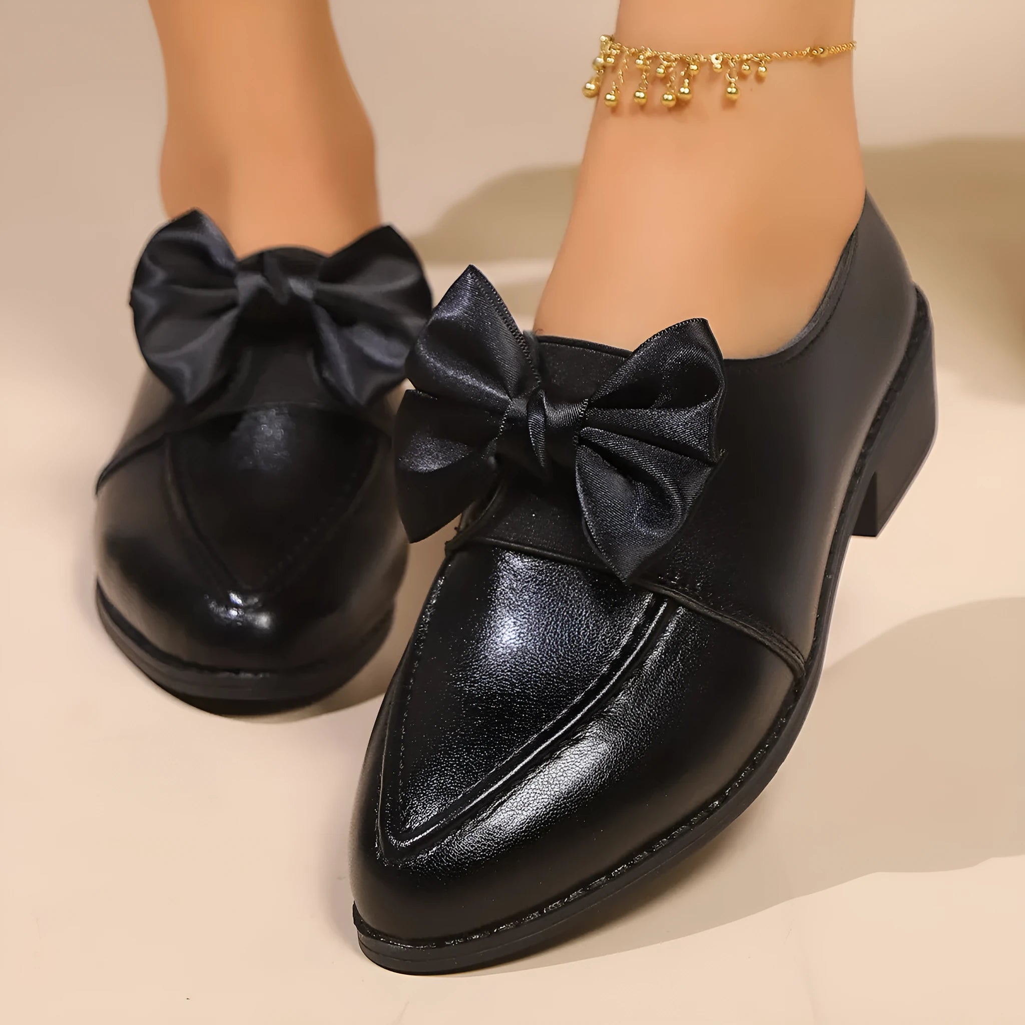 Women's casual leather shoes with a decorative bow on a pointed toe, showcasing a rubber sole.