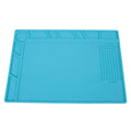 Blue silicone anti-skid watch repair mat on a workbench for horology tools.