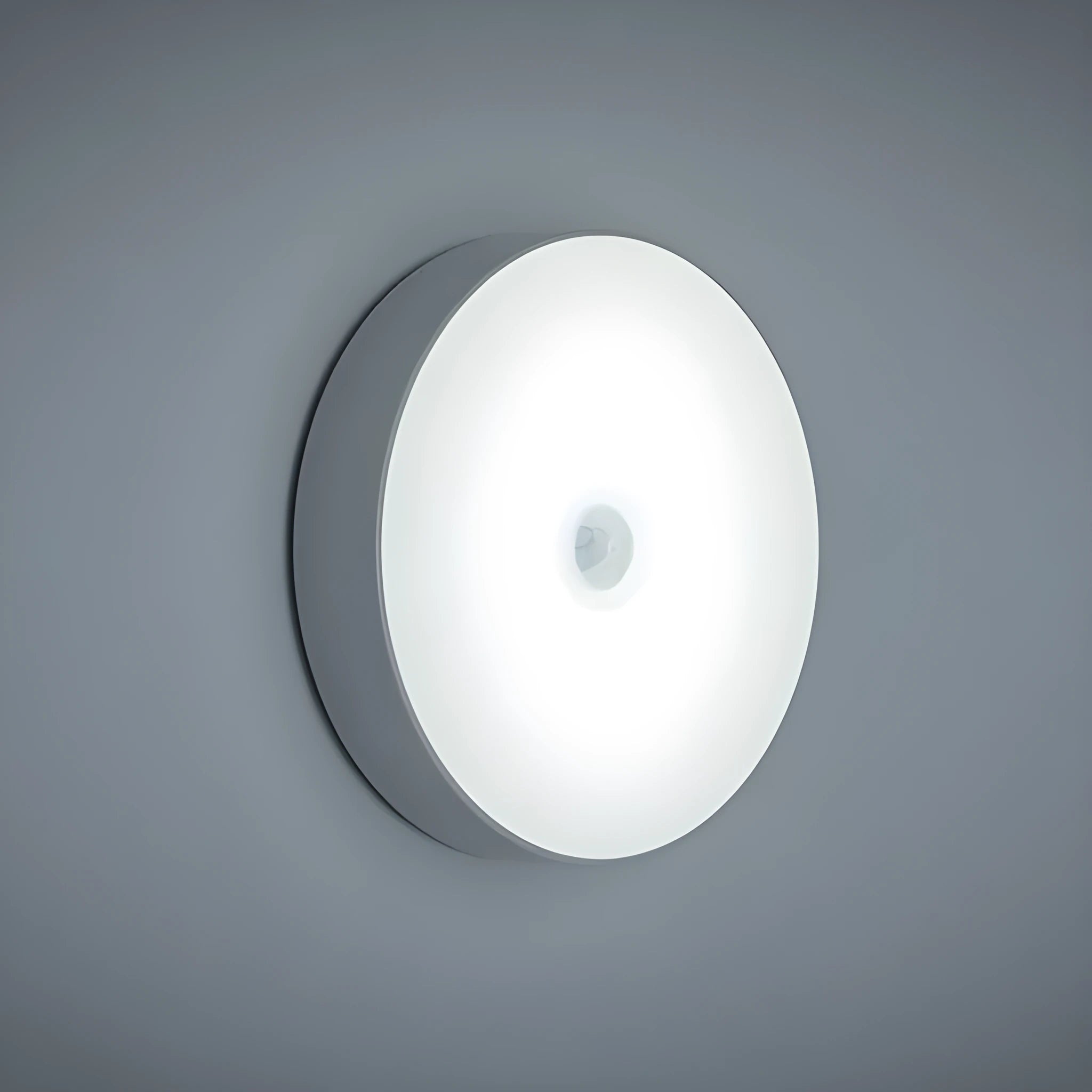 Compact round motion sensor LED night light in beige colour with USB charging cable