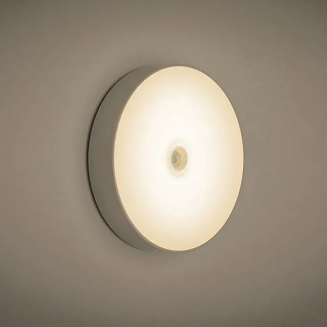 Compact round motion sensor LED night light in beige colour with USB charging cable