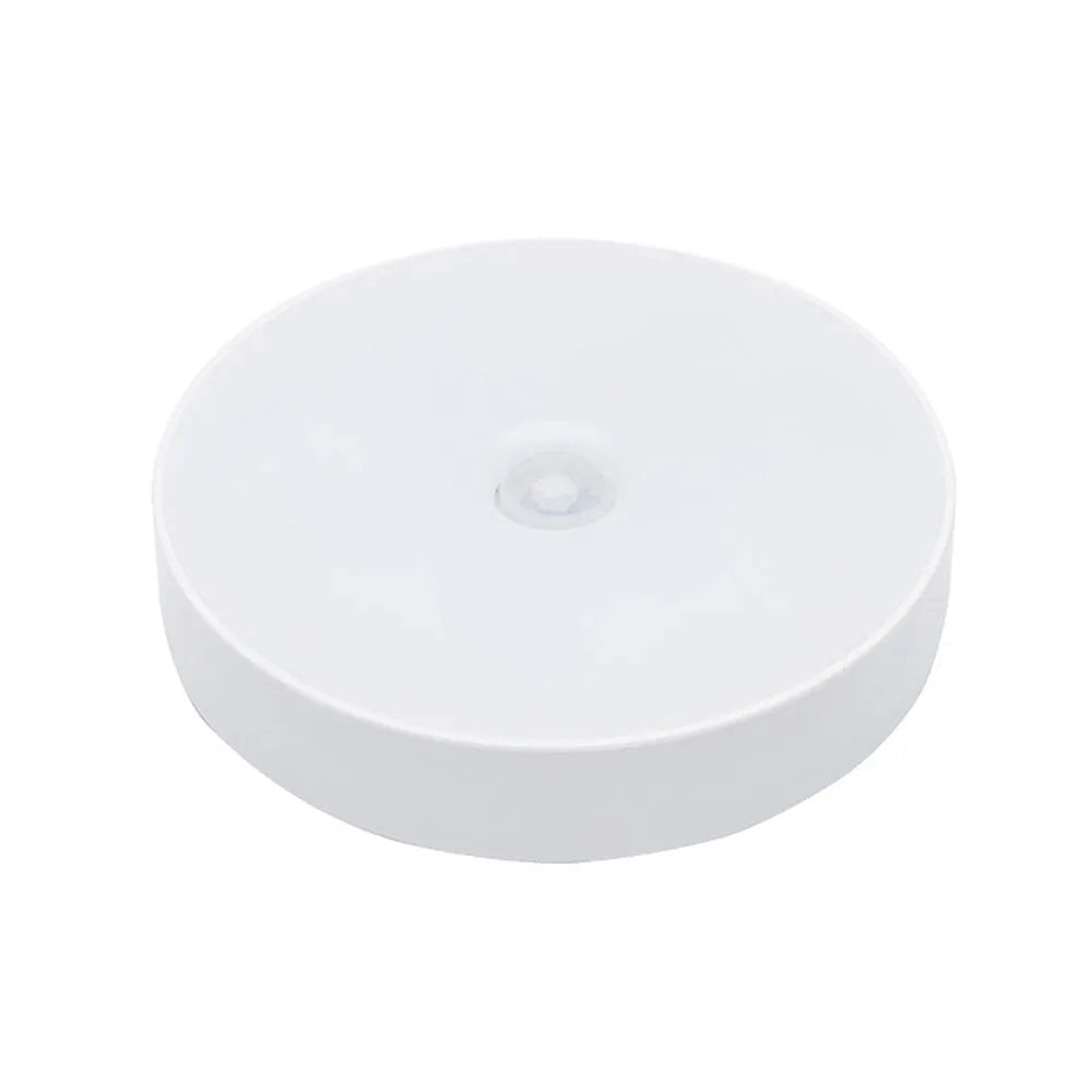 Compact round motion sensor LED night light in beige colour with USB charging cable