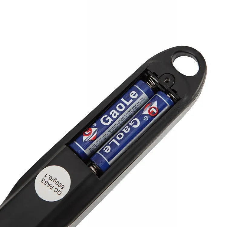 Digital smart measuring spoon with LCD screen showing weight, placed next to mixing bowl.