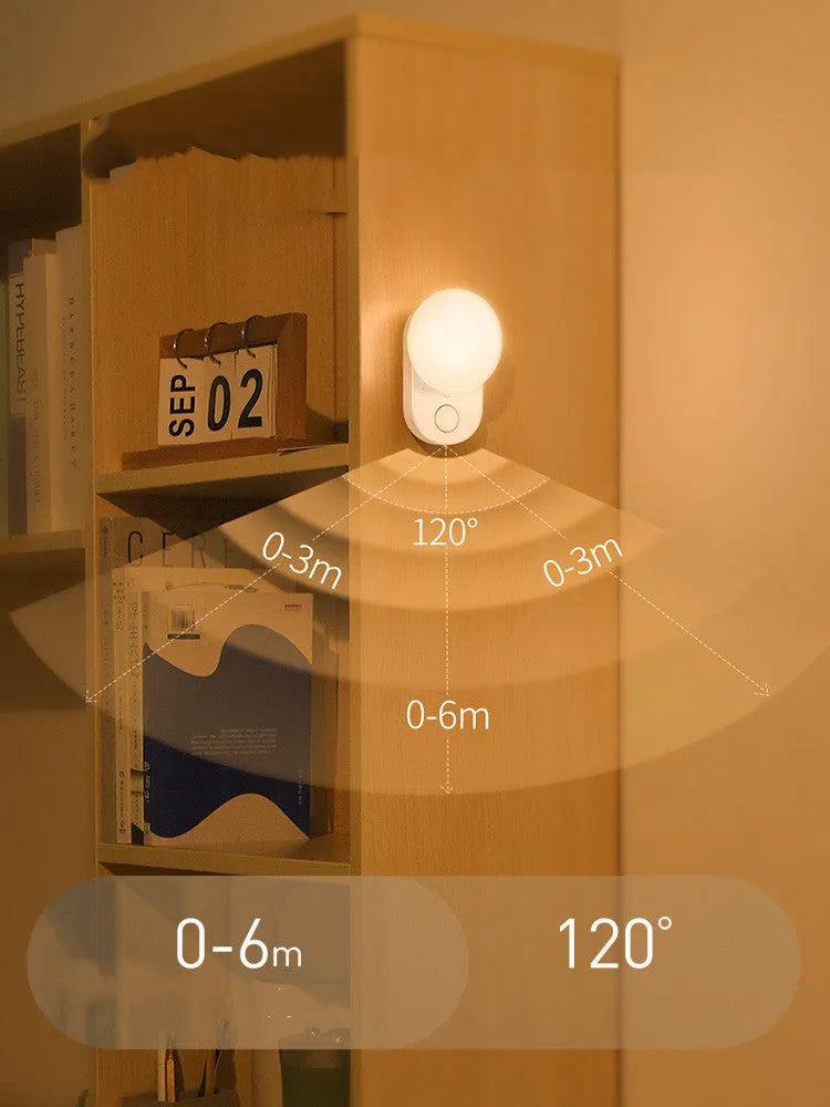 White Baseus rechargeable sensor night light with motion detection on a bedside table.