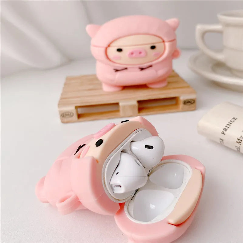 Pink silicone AirPods case cover with cartoon pig design, showing flip-style opening and hook attachment