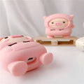 Pink silicone AirPods case cover with cartoon pig design, showing flip-style opening and hook attachment