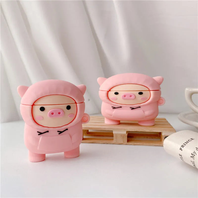 Pink silicone AirPods case cover with cartoon pig design, showing flip-style opening and hook attachment