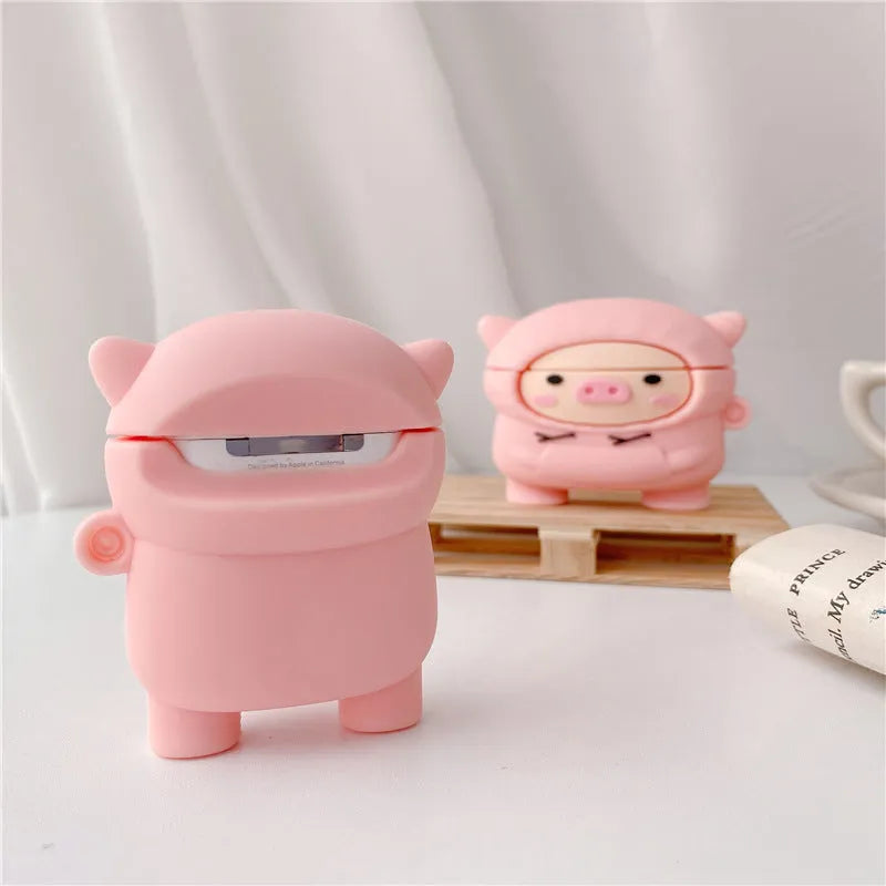 Pink silicone AirPods case cover with cartoon pig design, showing flip-style opening and hook attachment