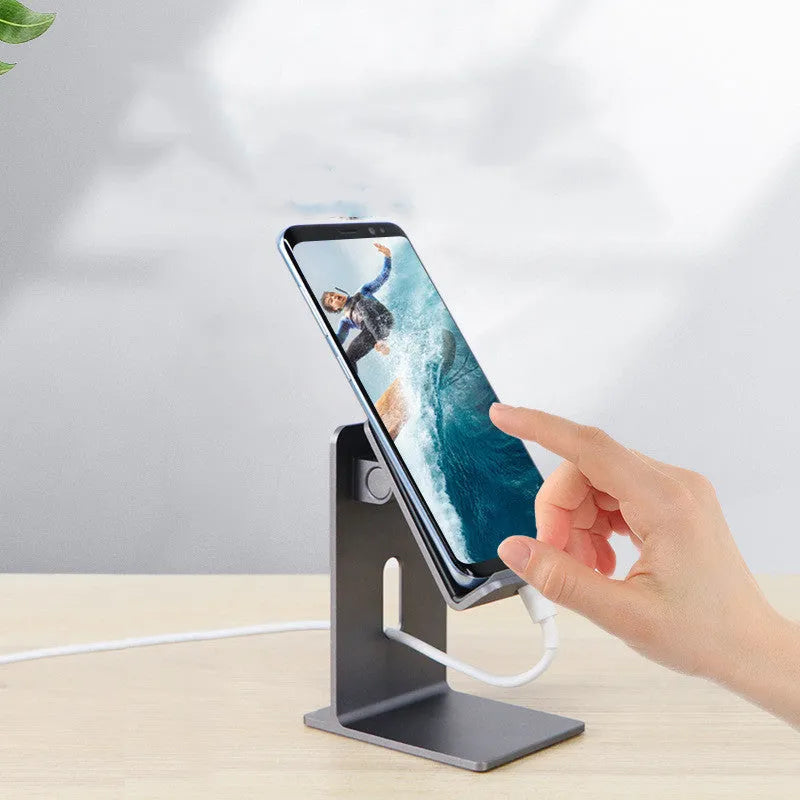 Dark grey aluminium alloy mobile phone holder with adjustable arm and clamp on a desk.