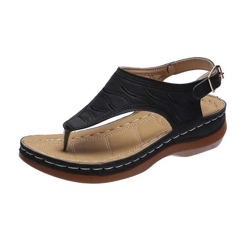 Women's black wedge heel sandals with an adjustable buckle back strap on a plain background.