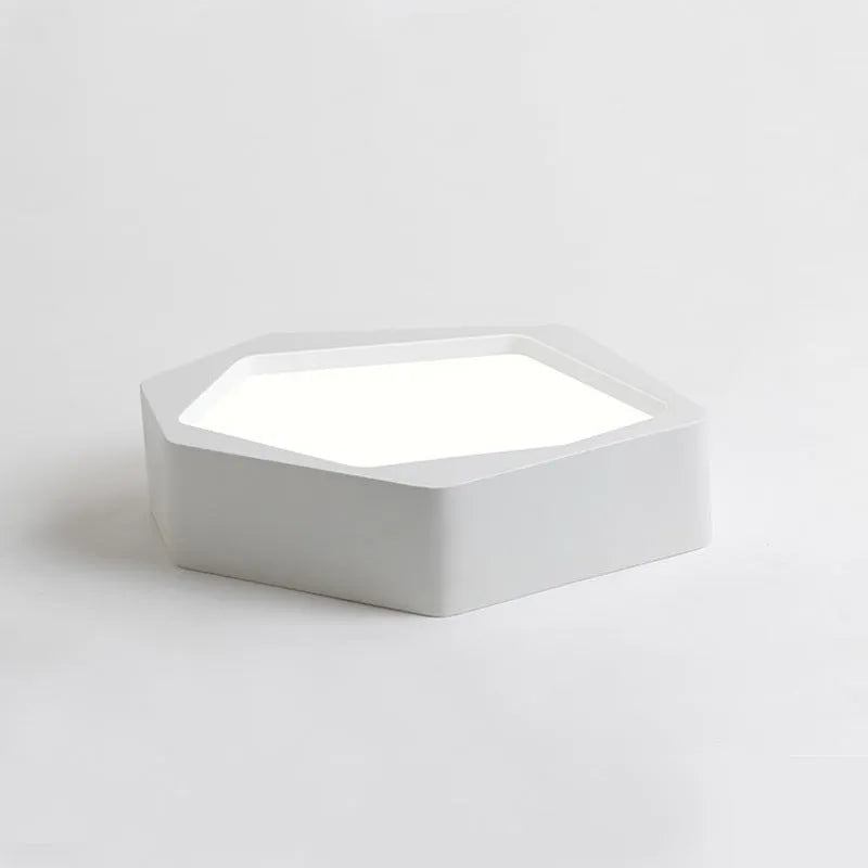 Geometric shaped black and white iron LED ceiling light with remote control on a table