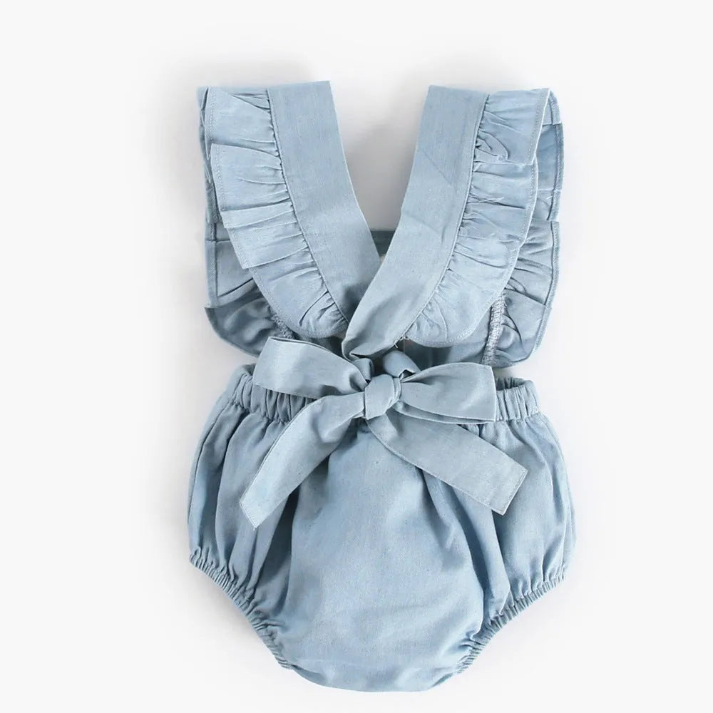 Blue denim sleeveless baby romper with lace detail and triangle neckline on a hanger.
