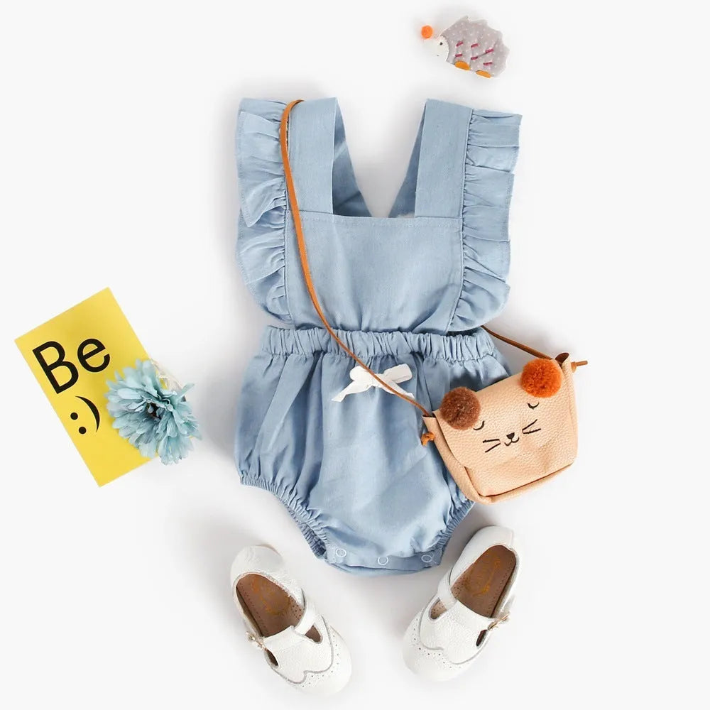 Blue denim sleeveless baby romper with lace detail and triangle neckline on a hanger.
