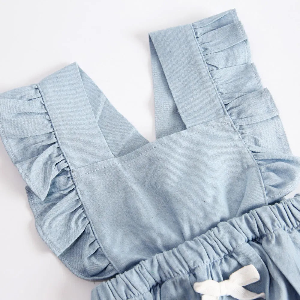 Blue denim sleeveless baby romper with lace detail and triangle neckline on a hanger.