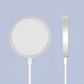 Silver metal magnetic wireless charger for iPhone on a wooden desk.