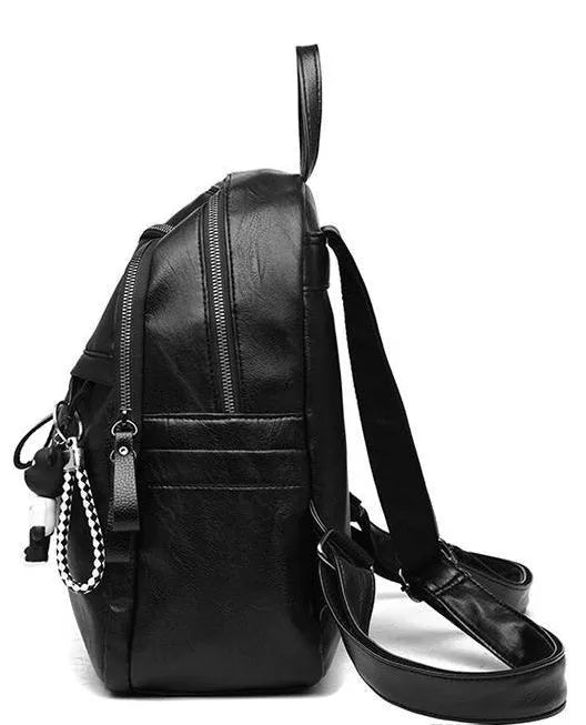 Black Pu leather soft surface backpack with double straps and a zippered opening.
