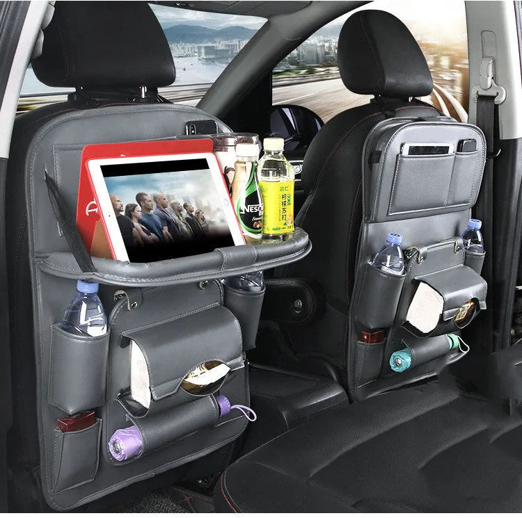 Black PU leather car seat back storage bag with multiple pockets hanging from a car headrest.