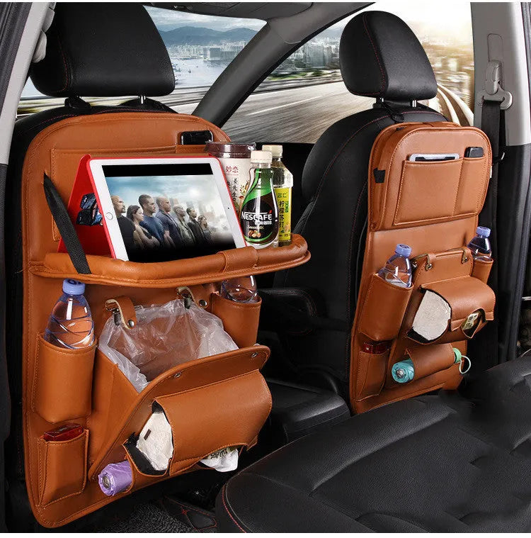 Black PU leather car seat back storage bag with multiple pockets hanging from a car headrest.