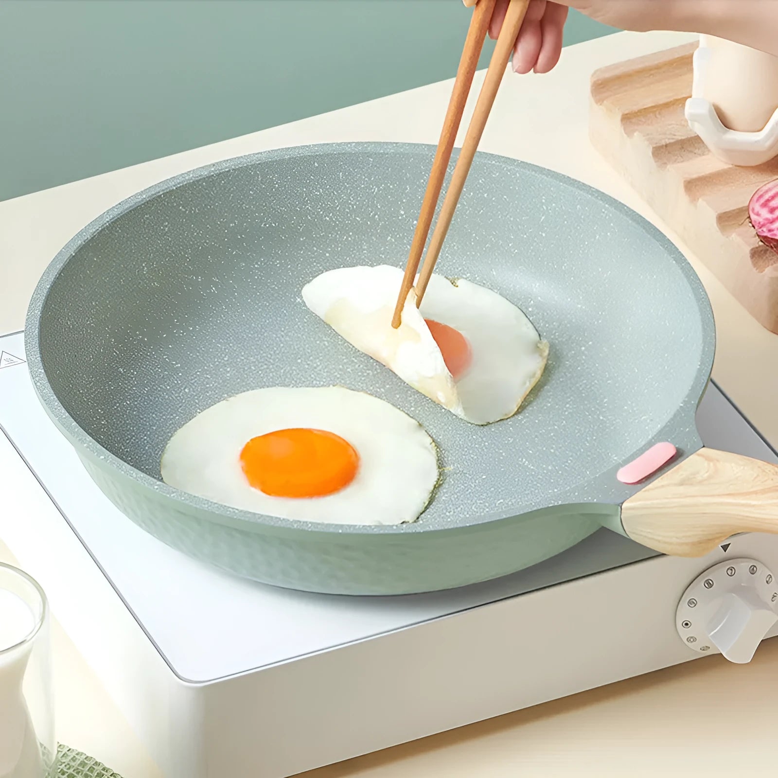 Korean style macadamite non-stick frying pan in green colour on a hob.