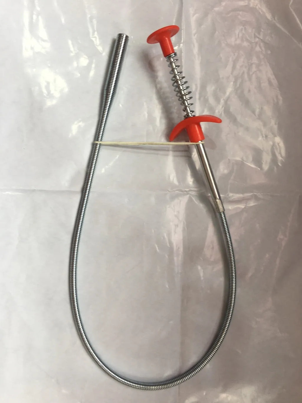 Flexible plastic and stainless steel drain cleaning spring tool with rubber grip for household pipe maintenance
