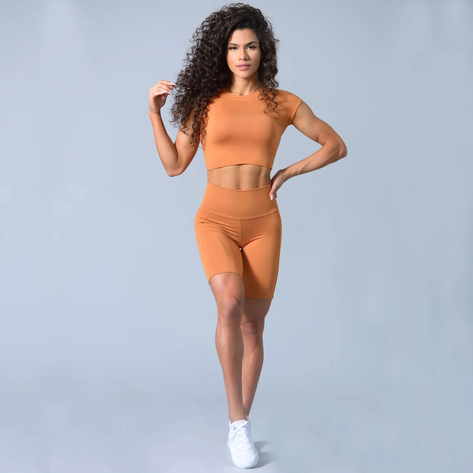 Cotton blended yoga sports suit with round neck, short sleeves, and shorts in green colour, side view on model.