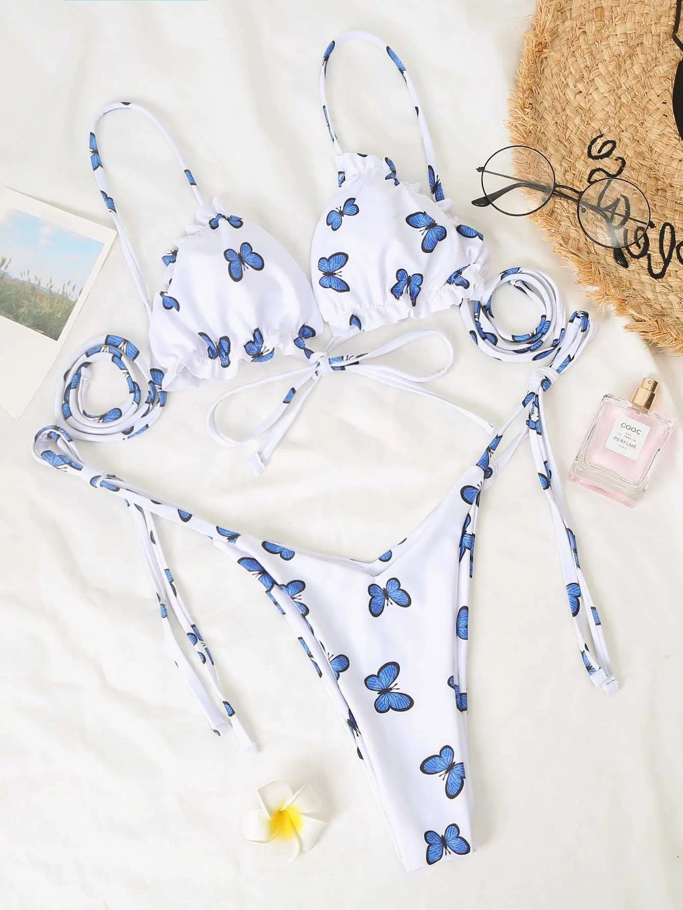 White butterfly print swimsuit with steel support top and lace thong bikini on display