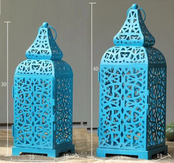 Blue retro geometric metal Moroccan-style candelabra holding a candle, showing hollow design.