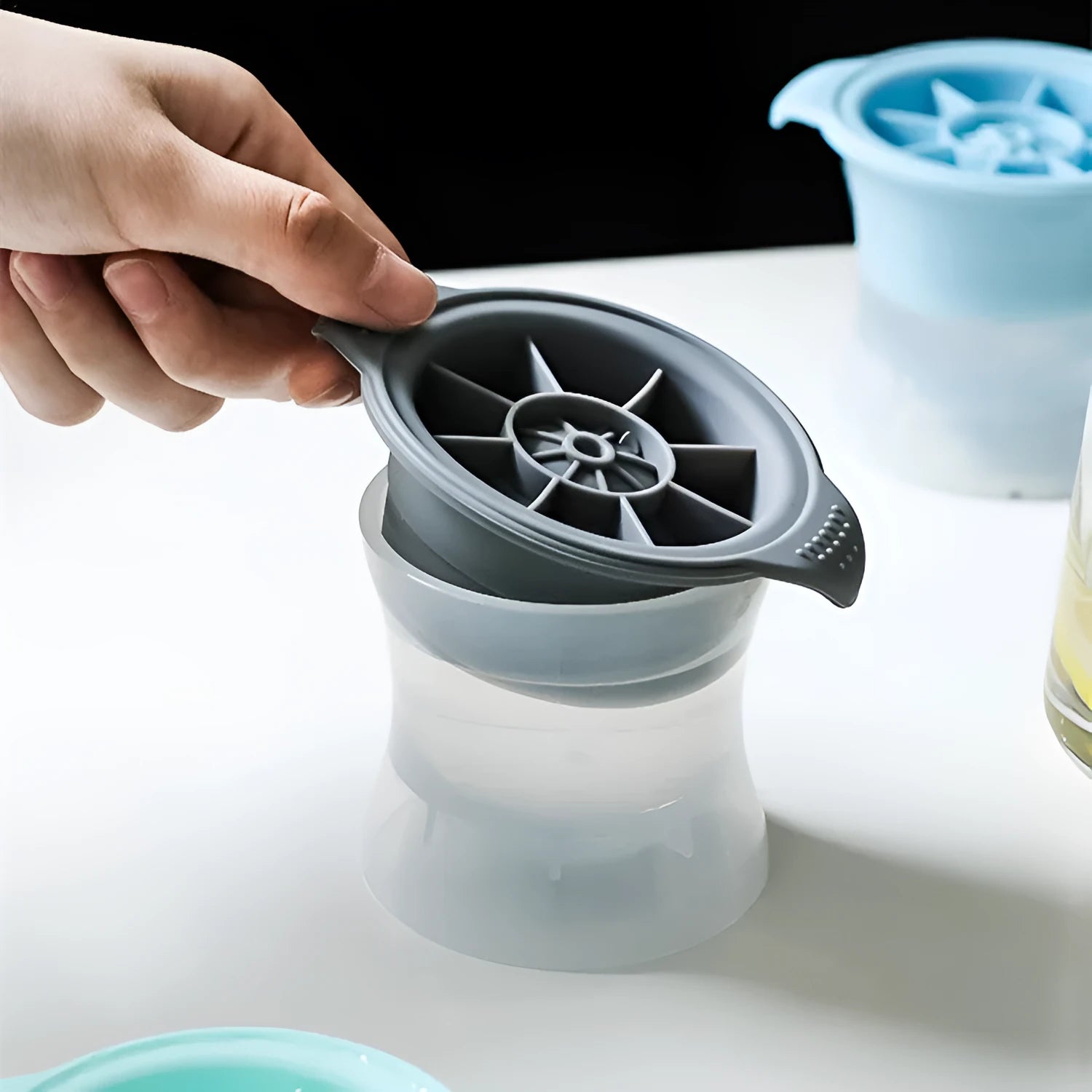 Silicone ice tray showing hockey puck, round, and pentagon shaped moulds in various colours