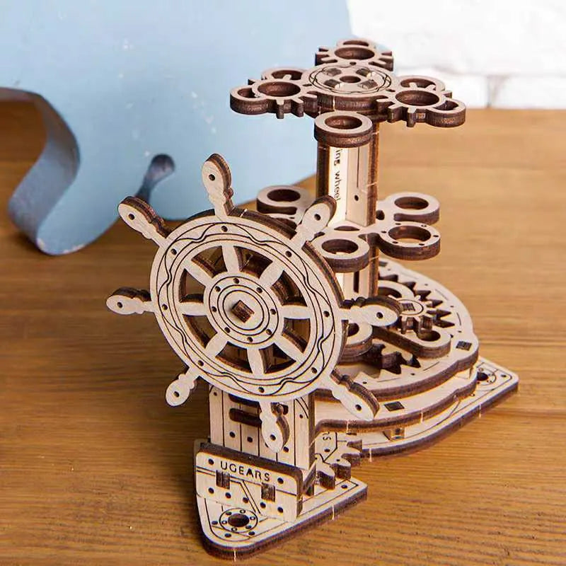 Ukrainian wooden model of a rotating steering wheel that functions as a pen holder on a desk.