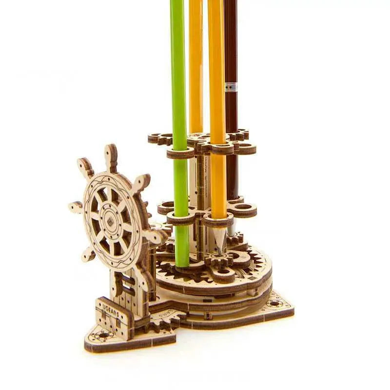 Ukrainian wooden model of a rotating steering wheel that functions as a pen holder on a desk.