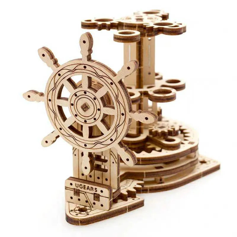 Ukrainian wooden model of a rotating steering wheel that functions as a pen holder on a desk.