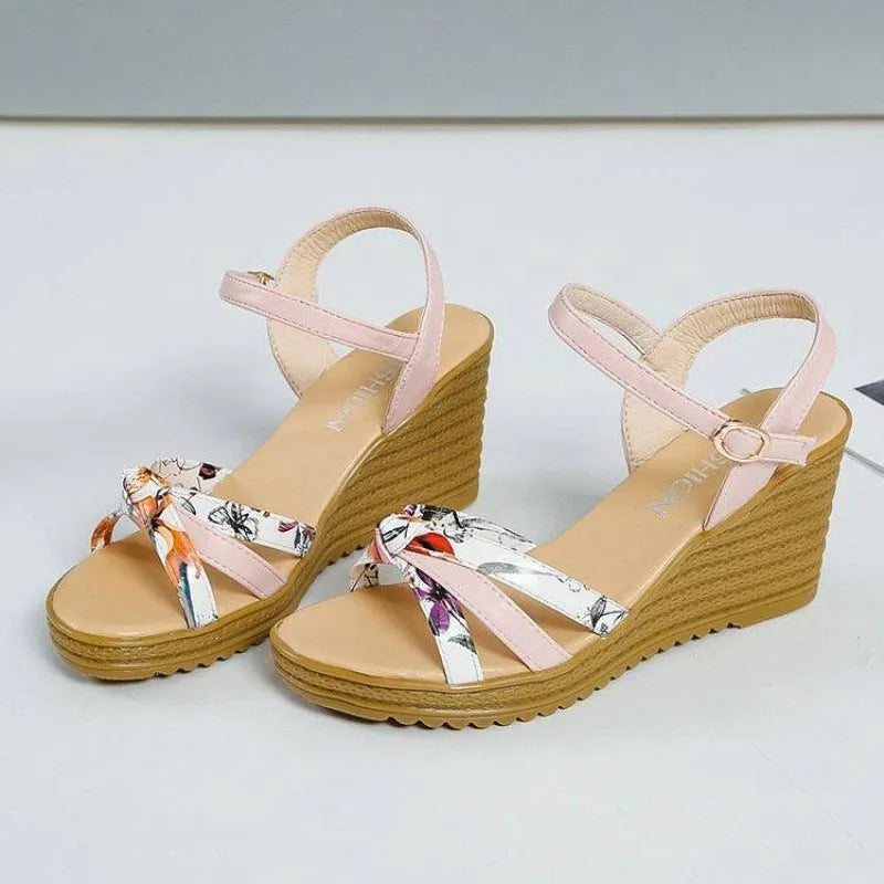 Pink women's wedge heel sandals with a fish mouth toe and buckle strap on a non-slip sole.
