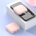 Compact black 20000mAh power bank with LED flashlight, showing scale next to a mobile phone.