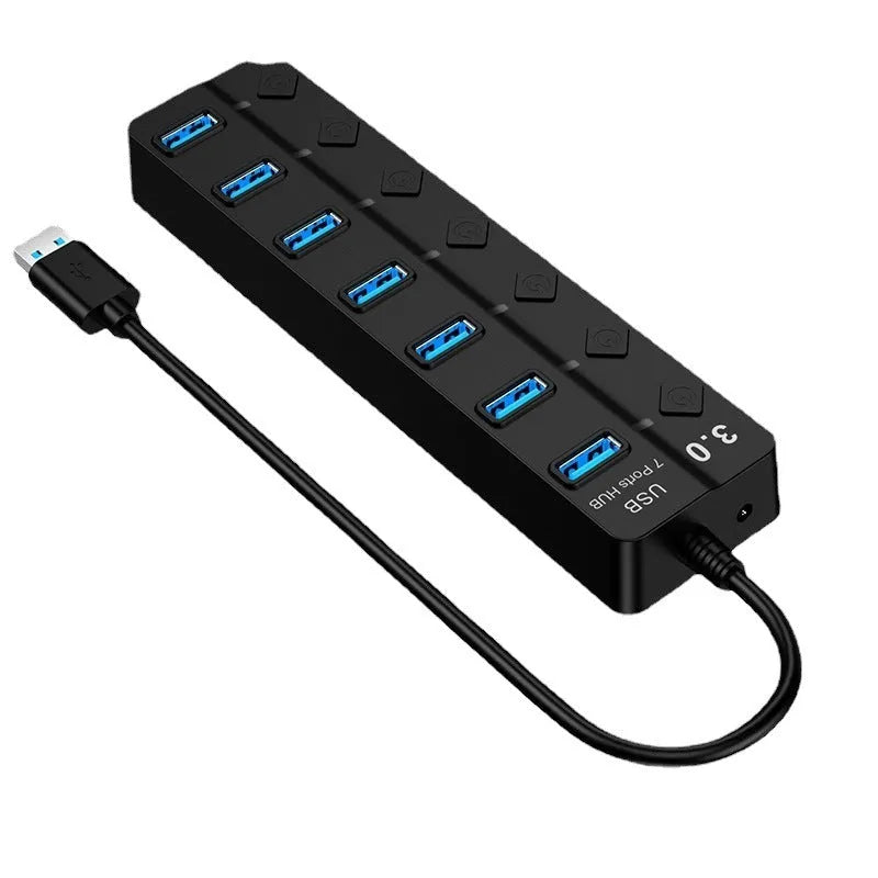 Black 7-port USB 3.0 hub with external power supply on a desk.