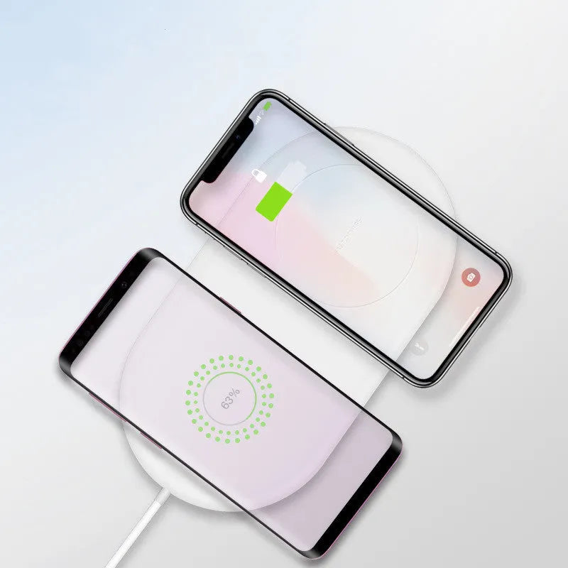 White dual wireless charging pad for two mobile phones on a table