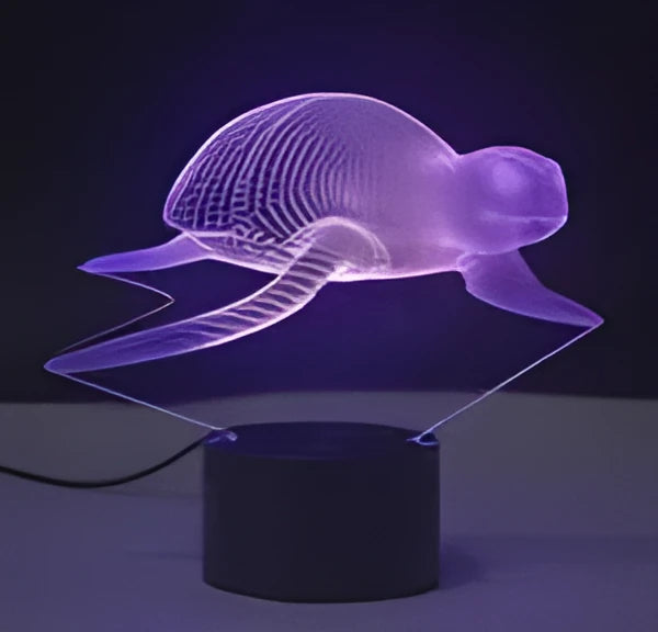 Small black and colourful 3D visual LED table lamp with remote control on a desk.