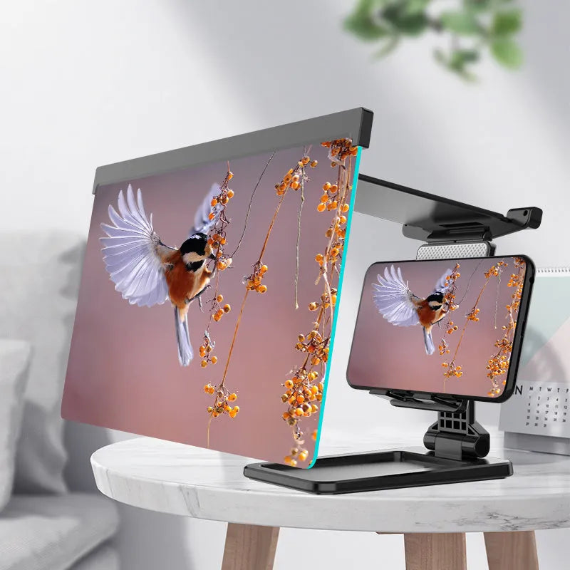 Black folding mobile phone screen amplifier with detachable holder on a desktop.