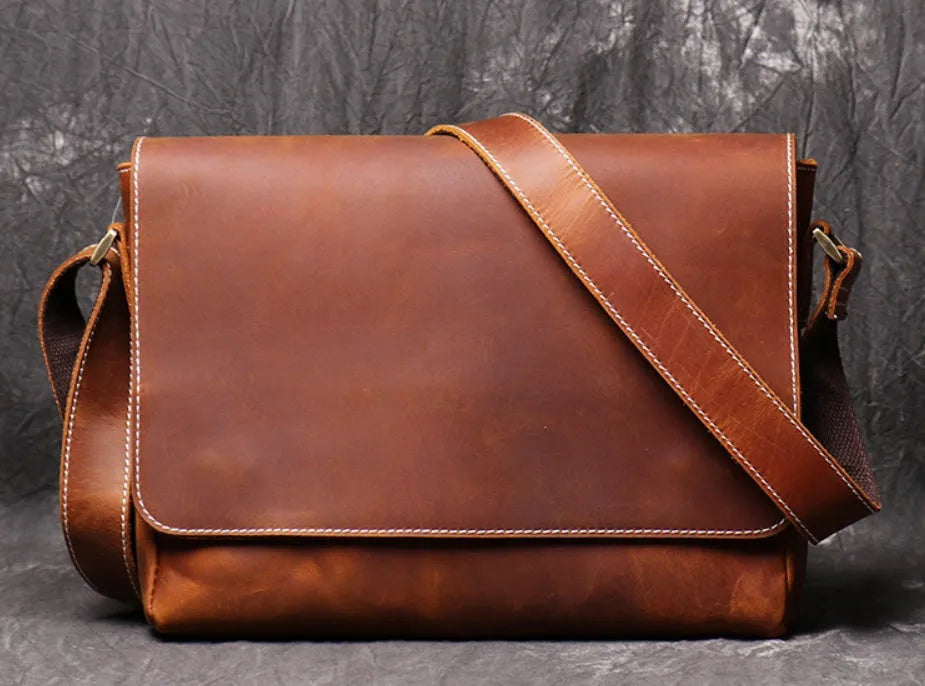 Vintage brown leather men's messenger bag with flap opening and adjustable shoulder strap.