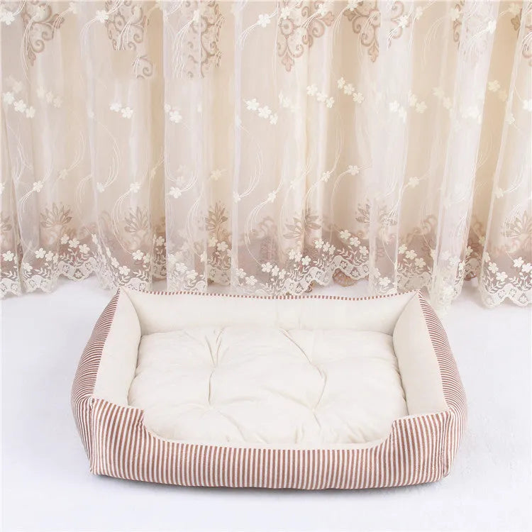 Round grey and white striped bolster dog bed on a wooden floor