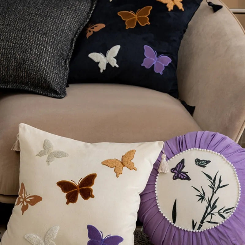 Square beige, black, and purple cushion with embroidered Chinese butterfly pattern.