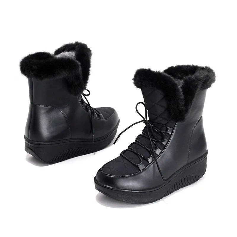 Women's black lace-up ankle boots with a platform sole on a wooden floor.