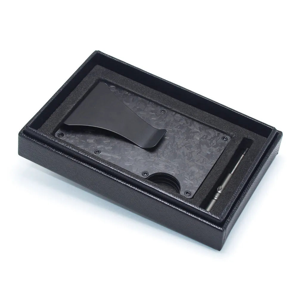 Geometric carbon fibre and aluminium business card holder, 8mm thick, on a table.