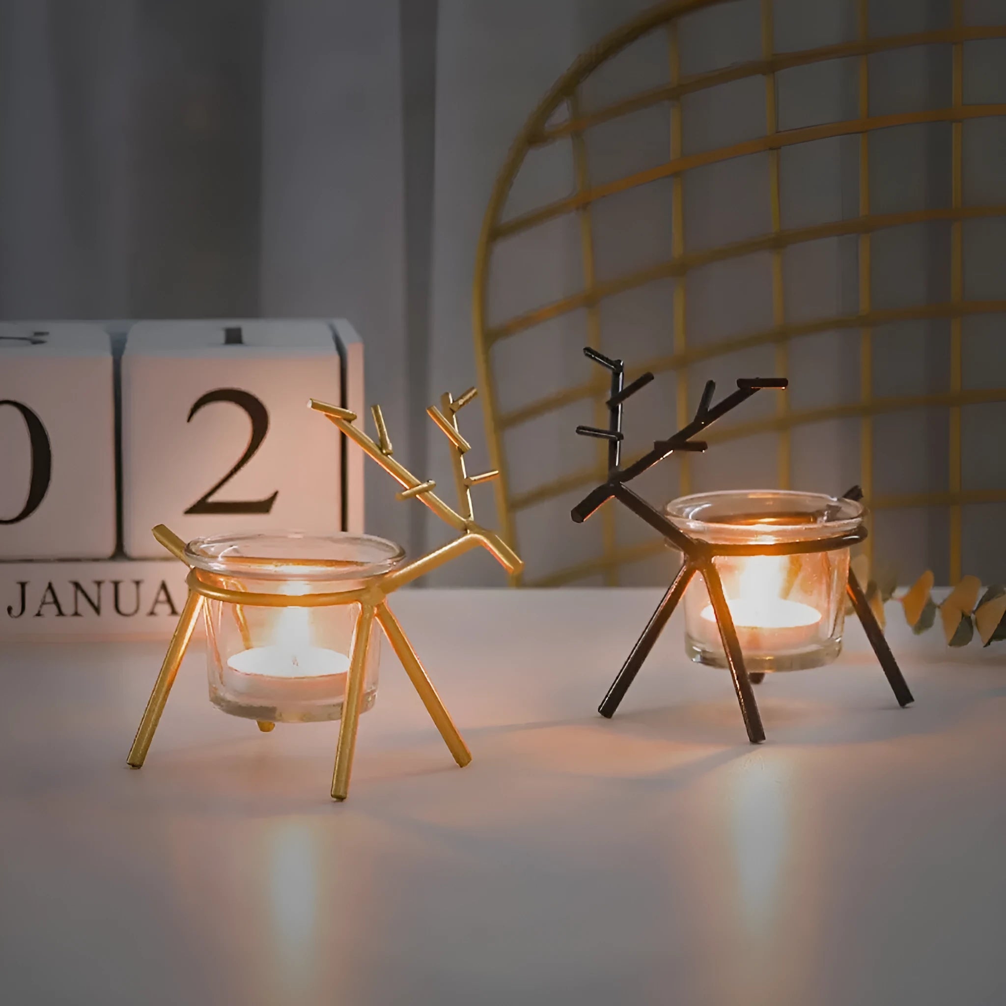 Wrought iron fawn candle holder with glass cup in gold electroplated finish on tabletop