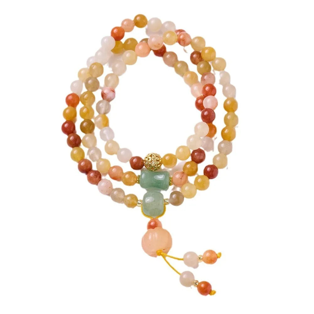 Handmade women's Jinsi Jade bracelet with three pumpkin beads and tassel on a wrist.
