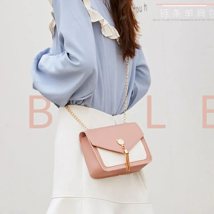 Small square PU leather crossbody bag with cat tassel decoration, magnetic flap, and adjustable chain strap in black